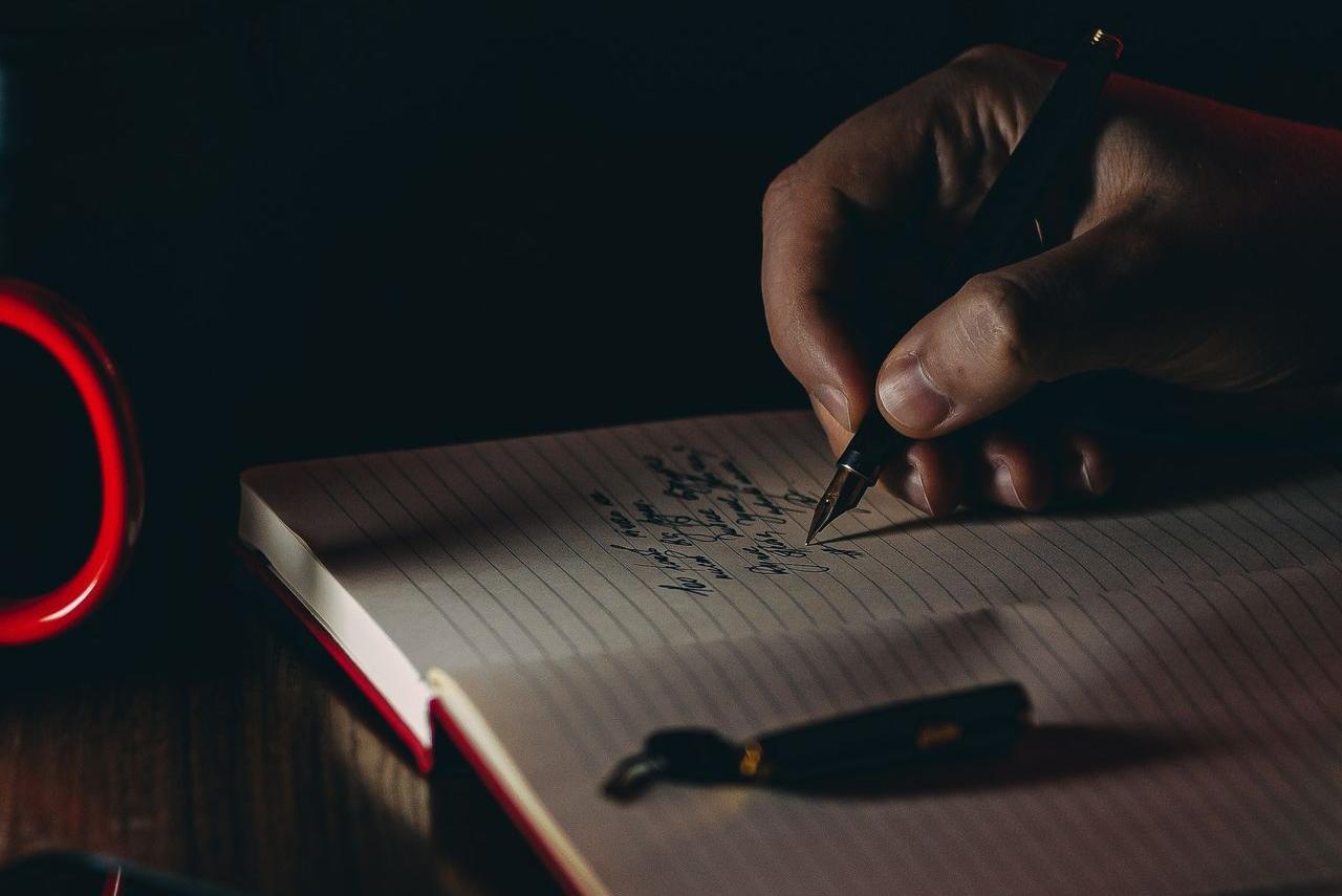 person writing on white paper